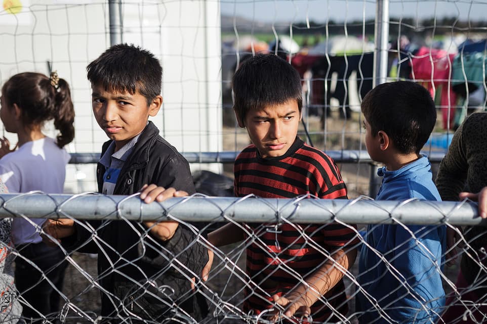 Children at a fence in a refugee camp
